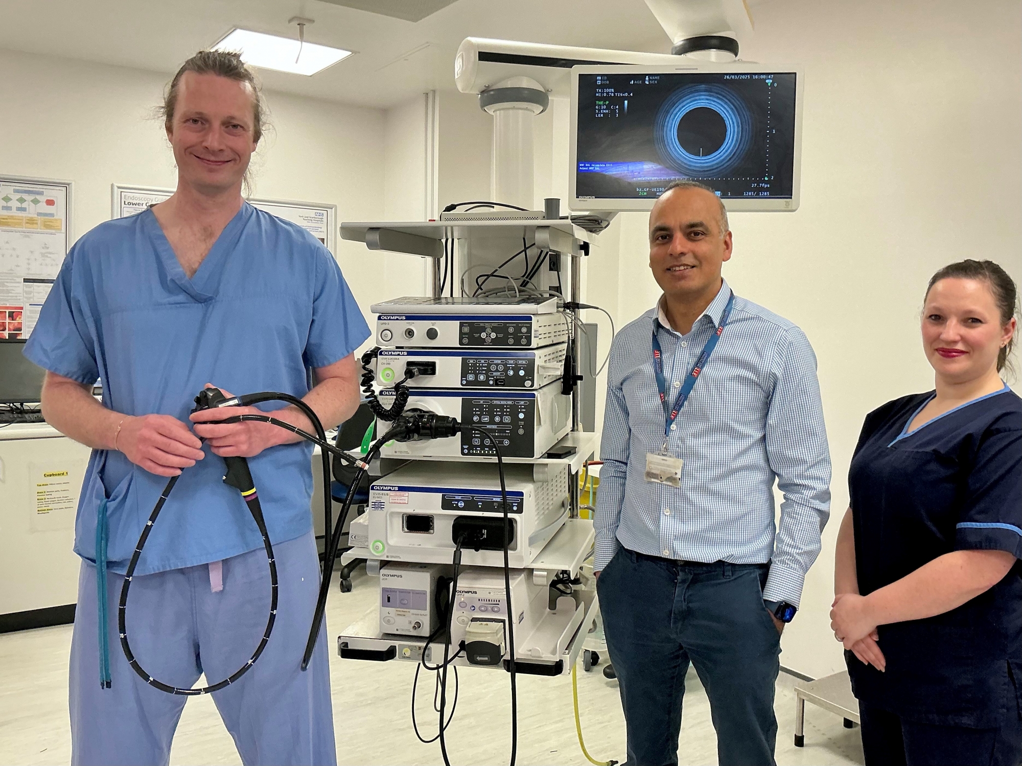 Colleagues alongside a large piece of healthcare equipment.
