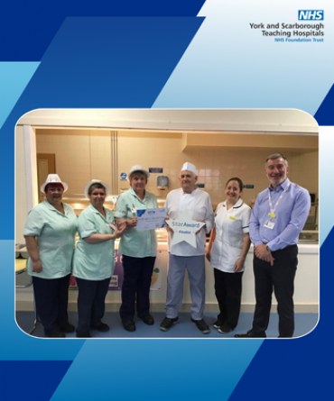 A group of people posing for a photo in a hospital restaurant.